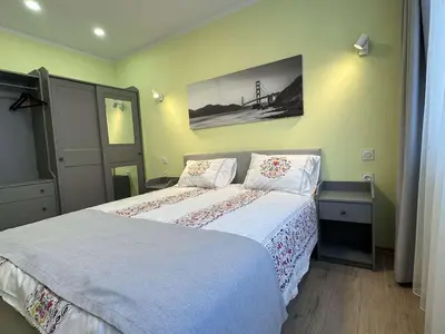 a bedroom with a bed and a picture on the wall at Unique flat with balcony in the heart of the city in Kyustendil