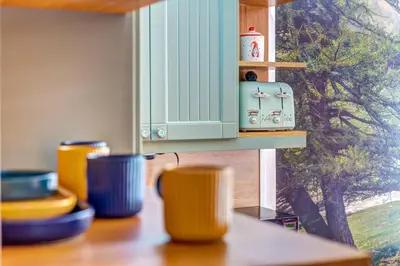 a table with cups on a shelf with a window at Into the Woods - Charming Studio by Flat Manager in Smolyan