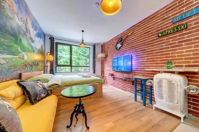 a living room with a couch and a brick wall at Into the Woods - Charming Studio by Flat Manager in Smolyan