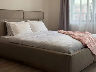 a bed with a pink blanket on it with a window at Coziness and comfort in the heart of tranquility in Sofia
