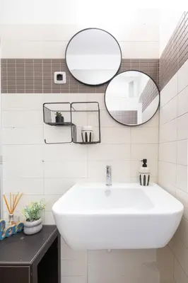 a bathroom with a white sink and two mirrors at Roca House in Sofia