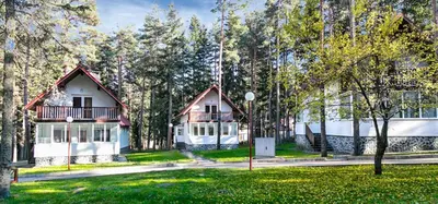 a house in the middle of a park with trees at Вилно селище Тракия- почивка сред природата in Tsigov Chark