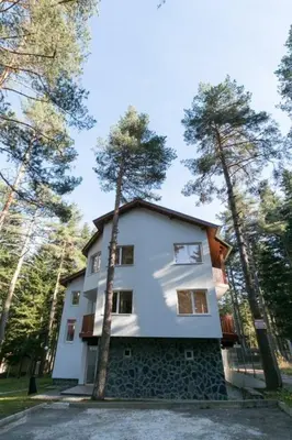 a white house with trees on the side of it at Вилно селище Тракия- почивка сред природата in Tsigov Chark