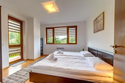 a bedroom with a large white bed and two windows at Pamporovo Palace - 2BD next to the Ski Slopes by Flat Manager in Pamporovo