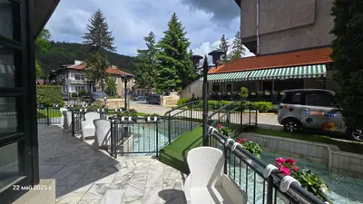a row of white chairs sitting next to a pool at Хотел Тото Шанс in Velingrad