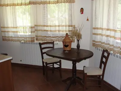 a dining room table with chairs and a vase on it at Villa Persenk in Lyaskovo