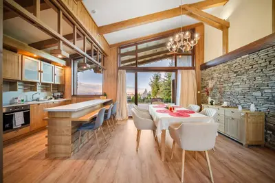 a kitchen with a table and chairs and a stone wall at Luxury Mountain Villa Pirin Golf K29H02 by Top Kvartiri Ltd in Razlog