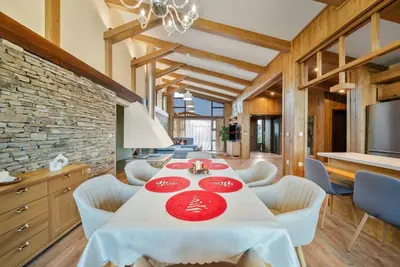a dining room with a table with red plates on it at Pirin Golf Lux Villa for Ski & Chill by Top Kvartiri Ltd in Razlog