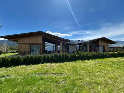 a house with a line of trees in front of it at Pirin Golf Lux Villa for Ski & Chill by Top Kvartiri Ltd in Razlog