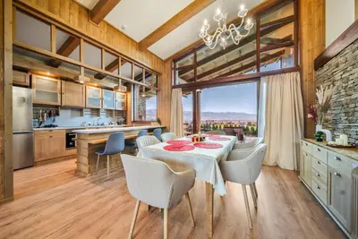 a kitchen and dining room with a table and chairs at Pirin Golf Lux Villa for Ski & Chill by Top Kvartiri Ltd in Razlog