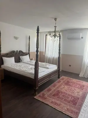a bedroom with a canopy bed with a rug at Комлекс Кристо in Blagoevgrad
