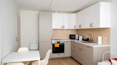 a small kitchen with white cabinets and a table at Cozy 1BD Apartment next to NDK by Flat Mаnager in Sofia