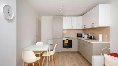 a kitchen with white cabinets and a table and chairs at Cozy 1BD Apartment next to NDK by Flat Mаnager in Sofia
