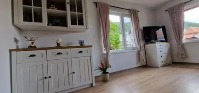 a kitchen with white cabinets and a television in a room at Бащината Къща in Sapareva Banya