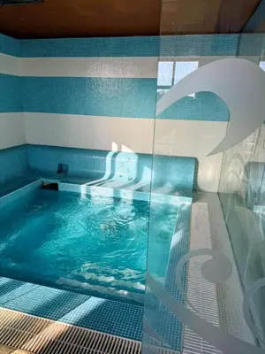 a large swimming pool with a blue tiled floor at Апартамент Елегант - спа комплекс Аква Терми in Krasnovo