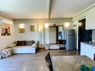 a living room with a white couch and a refrigerator at Апартамент Елегант - спа комплекс Аква Терми in Krasnovo