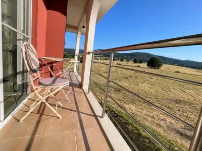 a chair on a porch with a view of a field at Апартамент Елегант - спа комплекс Аква Терми in Krasnovo