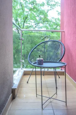 a chair sitting on a balcony with a table at Comfy & Chic Apartment , SWU , FREE Parking in Blagoevgrad