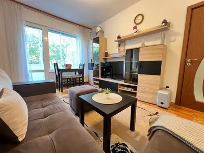 a living room with a couch and a table at Giza Cozy 1BDR w WiFi near Arena 8888 and SofiaMed in Sofia