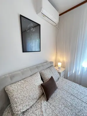 a bedroom with a bed with a television on the wall at Giza Cozy 1BDR w WiFi near Arena 8888 and SofiaMed in Sofia