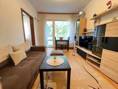a living room with a couch and a flat screen tv at Giza Cozy 1BDR w WiFi near Arena 8888 and SofiaMed in Sofia