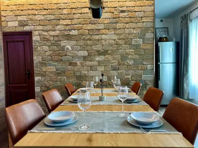 a dining room table with wine glasses and a brick wall at Alpine View Villa in Razlog