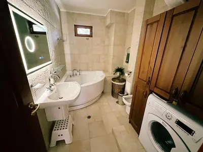 a bathroom with a tub and a sink and a washing machine at Alpine View Villa in Razlog