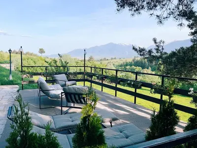 a patio with chairs and a view of a mountain at Alpine View Villa in Razlog