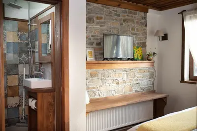 a bathroom with a sink and a stone wall at Къщата на музиканта in Leshten
