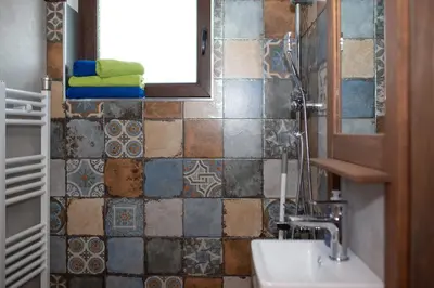 a bathroom with a sink and a window and tiles at Къщата на музиканта in Leshten