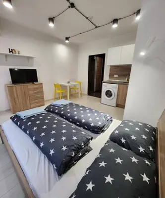 two beds in a room with a kitchen at Sunny Day in Sofia