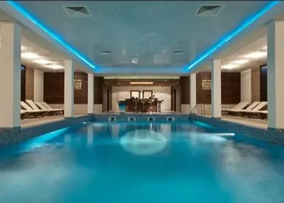 a large swimming pool with blue lights in a building at Crystal Apartment Bansko in Bansko