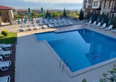 a large swimming pool with chairs at Crystal Apartment Bansko in Bansko