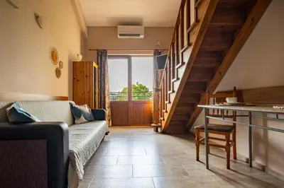 a living room with a couch and a staircase at Villa Veselina Loft Studios in Hisarya