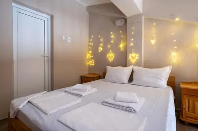 a bedroom with a white bed with lights on the wall at Villa Veselina Loft Studios in Hisarya