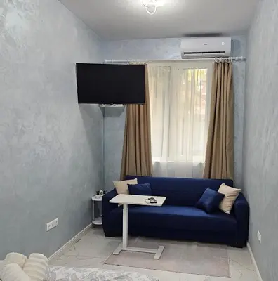 a living room with a blue couch and a tv at Urban Stay Sofia in Sofia