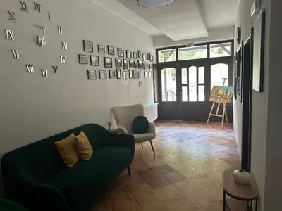 a living room with a green couch and a chair at TRIIBRIA Guest house in Trigrad