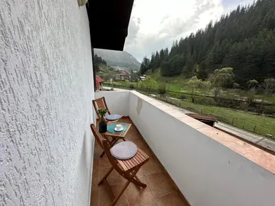 a balcony with two chairs and a table at TRIIBRIA Guest house in Trigrad