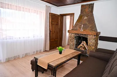 a living room with a table and a fireplace at Къща Джано in Dobrinishte
