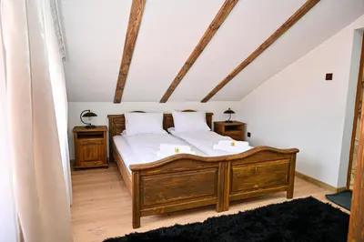 a bedroom with a wooden bed and two night stands at Къща Джано in Dobrinishte