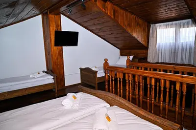 a bedroom with two beds and a tv in it at Къща Джано in Dobrinishte