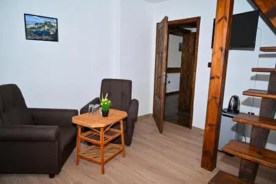 a living room with a chair and a table at Къща Джано in Dobrinishte