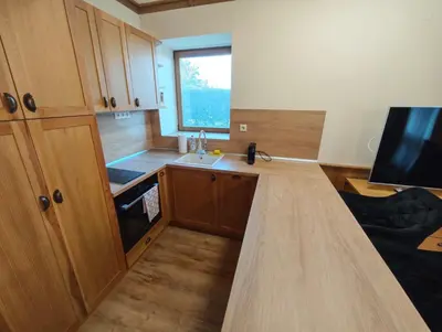 a kitchen with wooden cabinets and a counter top at Apartment 78 by the pool in Bansko