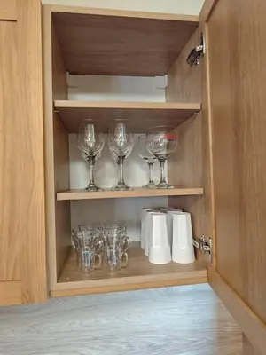 a cupboard with wine glasses and paper towels at Apartment 78 by the pool in Bansko