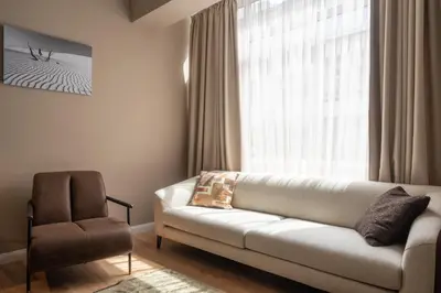 a living room with a couch and a chair at Amber Corner I Brand New Flat Top Location in Sofia