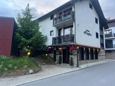 a building with a balcony on the side of it at Guest House Raffe in Dobrinishte