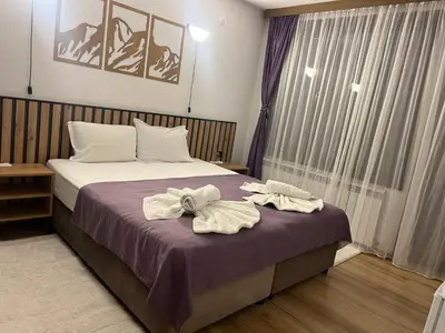 a bedroom with a bed with towels on it at Guest House Raffe in Dobrinishte