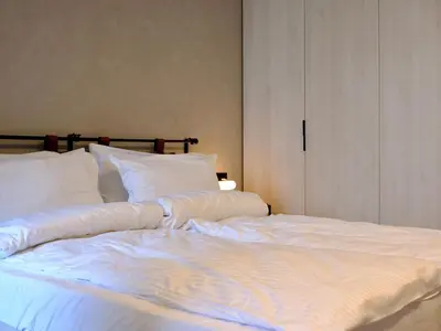 a large white bed with white sheets and pillows at Eleve Residences - Stone Studios in Sofia
