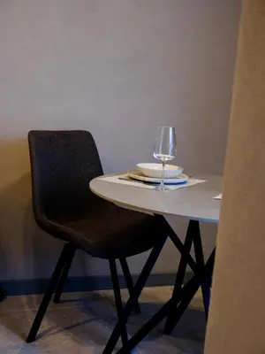 a table with a chair and a wine glass on it at Eleve Residences - Stone Studios in Sofia