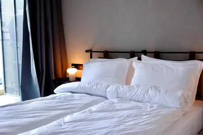 a white bed with white sheets and pillows at Eleve Residences - Stone Studios in Sofia